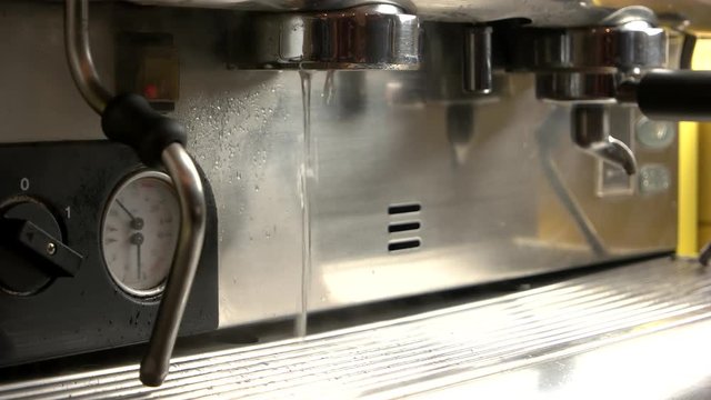 Coffee machine pouring hot water. Hand of man holding portafilter.