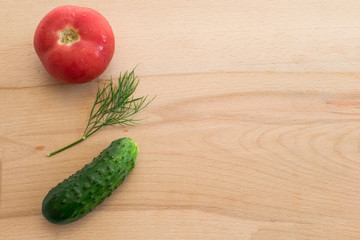 Tomato, dil and cucumber on the kitchen board