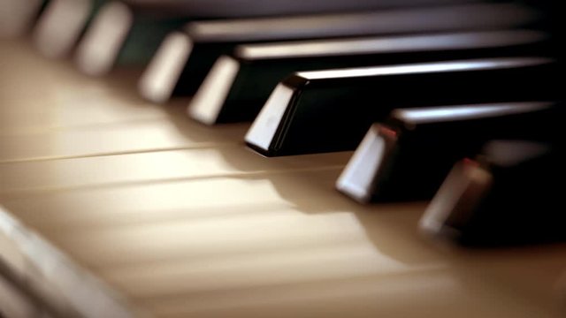 Piano keys close up. Yellow color correction, loopable (4K,ultra high definition 2160p, seamless loop)