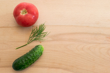 Tomato, dil and cucumber on the kitchen board