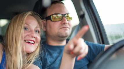 Happy young couple travels in the car