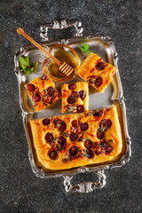 Italian homemade fresh focaccia bread with grapes, gorgonzola cheese and honey. Refined appetizer for vegetarians and gourmets in a baking dish