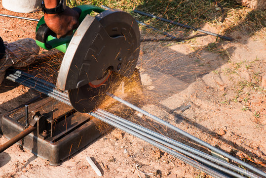 Gring on steel pipe and fire sparkles, Cuting steel rods at the building site