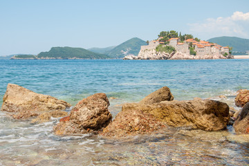 A view of the Sveti Stefan island and the mountains on a summer day, Montenegro