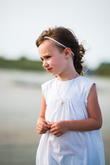 Young girl on beach old white dress