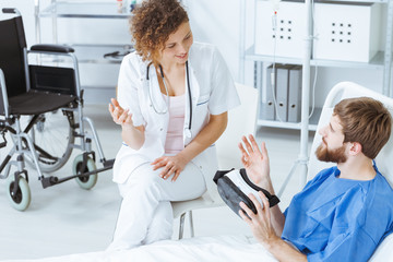 Man with VR goggles talking to doctor