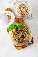 Eggplant caviar. Italian pesto of eggplant in a glass jar on a white marble table. Canning