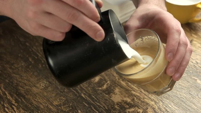 Barista making latte. Espresso with steamed milk. Latte art training.