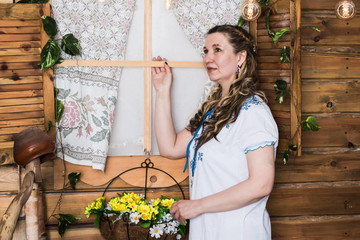 Ugly woman in national dress posing in a rustic interior