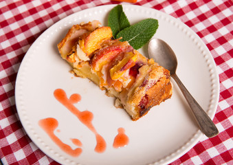 part of clafoutis with peaches in a white plate