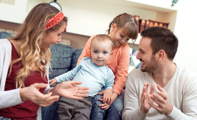 Cheerful family at home sitting in sofa