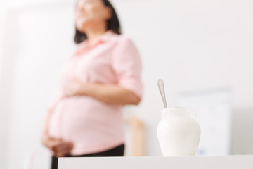 Fototapeta na wymiar Pregnant woman going to eat healthy natural jogurt