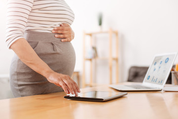 Pleasant pregnant woman using a tablet