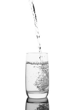 Pouring water in a glass, isolated on a white background