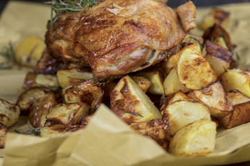 Pollo intero cotto alla brace con rosmarino e patate sopra carta da forno