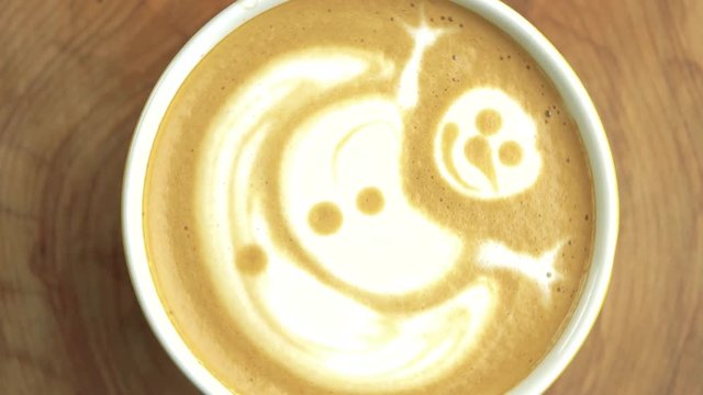 Latte art snowman. Coffee cup, top view.