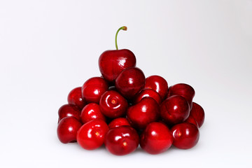 Handful of red ripe delicious cherries on white background