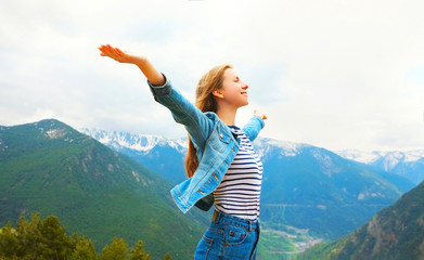 Travel happy woman enjoys fresh air mountains raises hands up, view of Spain landscape background