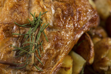 Dettaglio di pollo cotto alla brace con rosmarino e patate