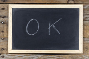 Space chalkboard background texture with wooden frame with the word "OK". blackboard space for wallpaper. Landscape mounting style horizontal.
