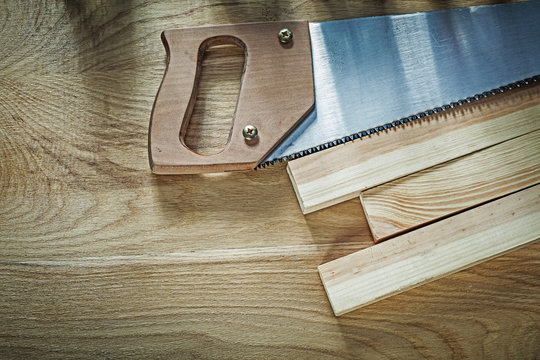Hacksaw wooden planks on wood board construction concept