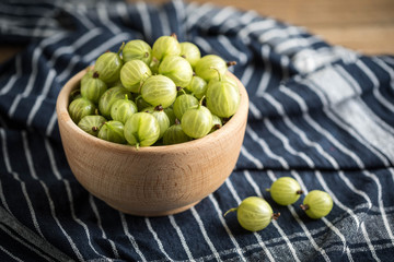 Fresh gooseberry in a wooden bowl.