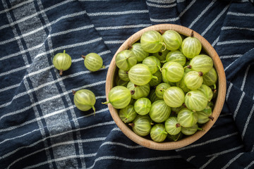 Fresh gooseberry in a wooden bowl.