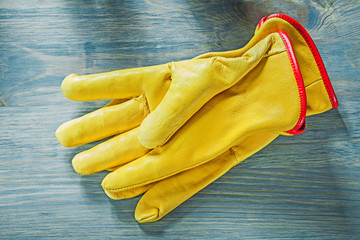 Pair of working gloves on wooden board construction concept