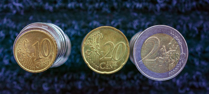Columns of euro coins on a dark abstract background