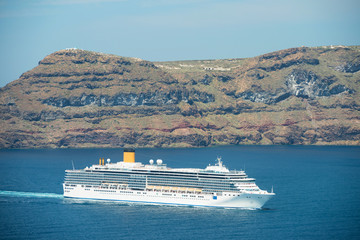Fototapeta na wymiar Cruise ship on the way to Santorini, Therasia island on the background, Greece