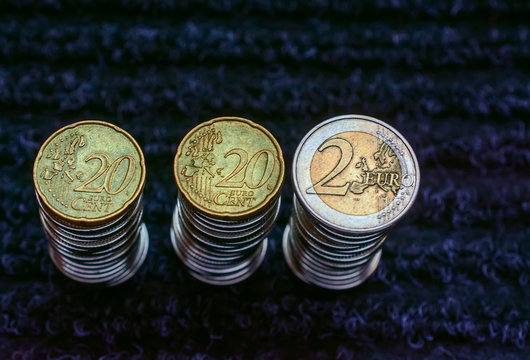 Columns of euro coins on a dark abstract background