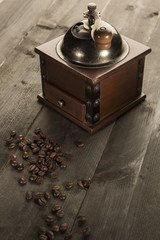 Antico macinino di caffè e chicchi di caffè sopra un tavolo di legno