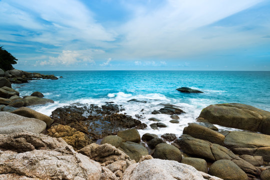 Big wave impacting the rock on coastline ..Beautiful seascape of Kata beach ,Phuket with blue cloudy sky.