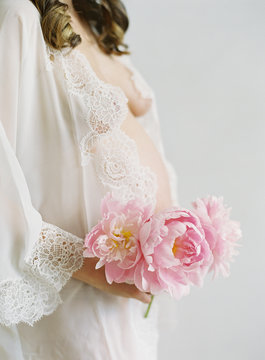 Pregnant woman holding peony 