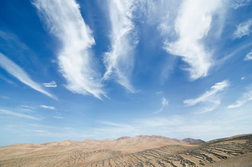 Fototapeta na wymiar Blue cloudy sky and desert