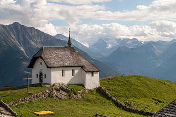 A small chapel on top of a mountain in the Swiss Alps.