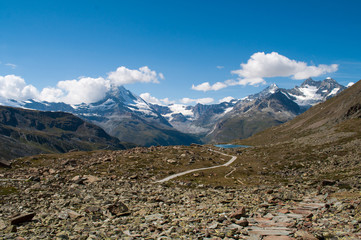 Hiking path in the mountains among the stones in the Swiss Alps.