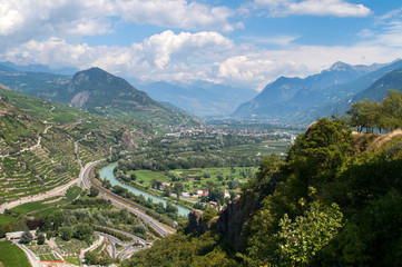 Fototapeta na wymiar Valley with river and fields and mountains in the background - Sion, Switzerland