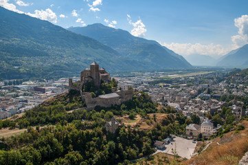 Fototapeta na wymiar Old stone castle and small town in the middle of high mountains (Sion, Switzerland)