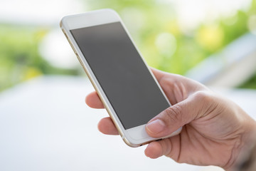 Technology and Security concept. Young woman holding smart phone and use thumb to unlock phone security.