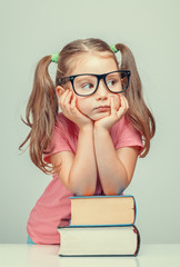beautiful cute little girl leaning on thick books
