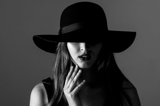 Black and white portrait of beautiful sexy woman in black hat