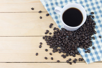 Hot coffee and coffee bean on napkin with blue plaid