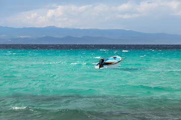 Single boat in the infinite turquoise aegean sea,  Kassandra, Greece.