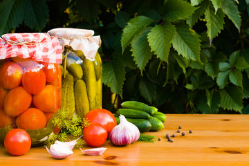 Fresh Home Canned Tomatoes And Pickled Cucumbers On Wooden Table With Copyspace.