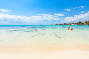 Fototapeta na wymiar Playa del Carmen - relaxing on chair at paradise beach and city at caribbean coast of Quintana Roo, Mexico