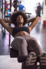 black woman doing sit ups at the gym