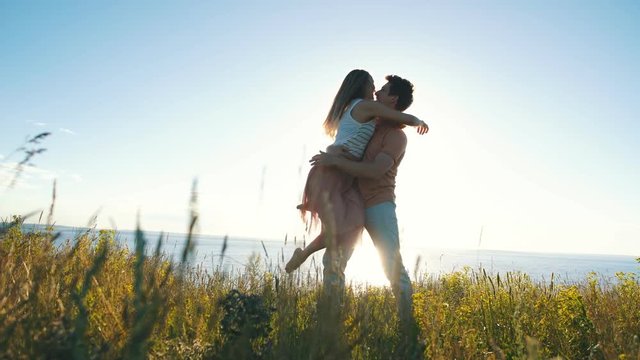 happy couple dancing at the edge of the cliff on the background of the river