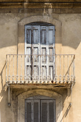 Old rustic balcony and window with shutters in Provence, France