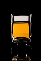 Glass of whiskey on black background